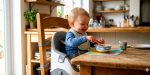 Bébé sur un rehausseur de chaise pour bébé