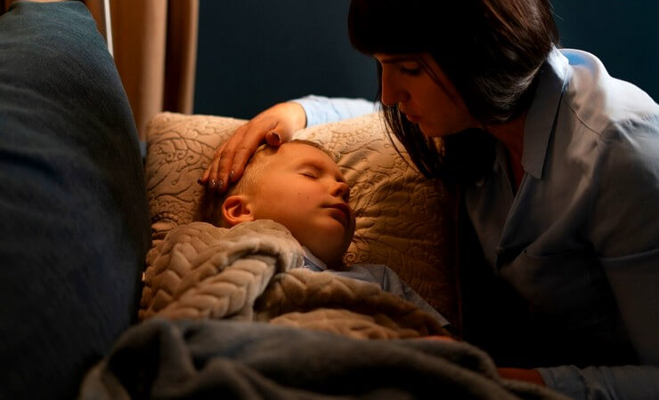 Maman à côté de son enfant au lit